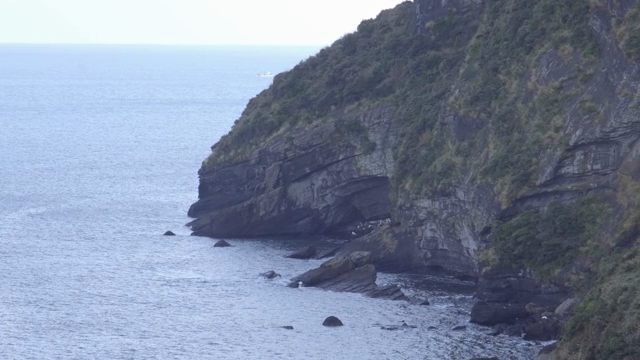 Rocky cliff by the sea with waves
