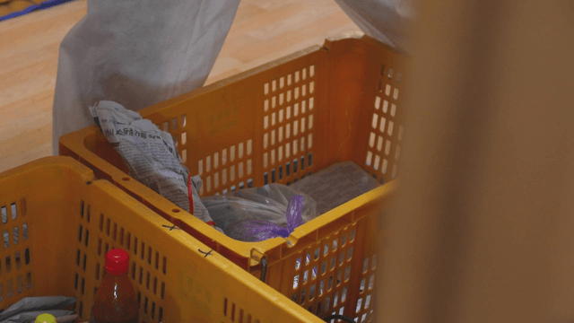Person putting groceries into a yellow basket