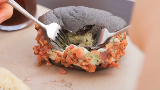 A fork cutting into a stuffed bagel