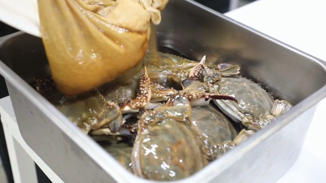 Soy sauce being poured over crabs