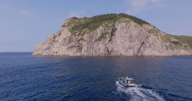 A boat approaching a rocky island