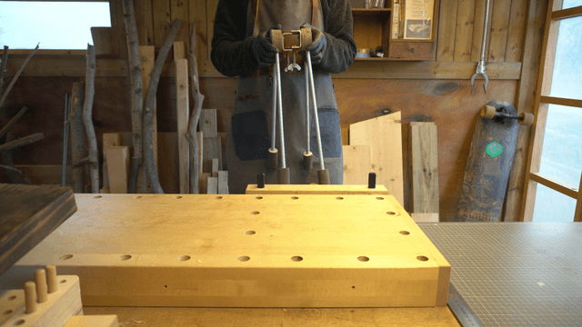 Woodcraft artisan shaking a wooden piece with metal brackets