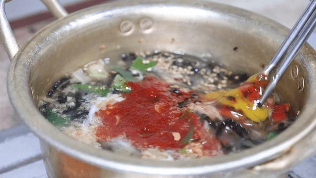 Chicken noodle soup with egg mixed by chopsticks