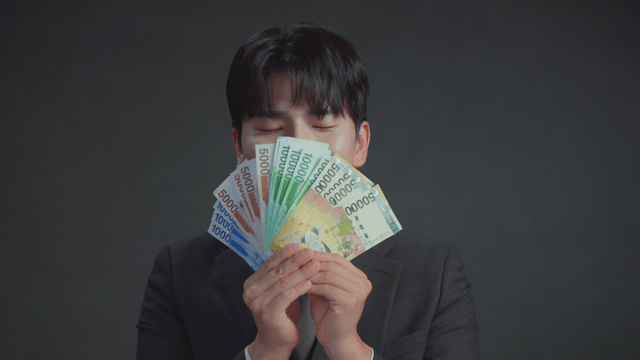 Man smelling money with a satisfied expression