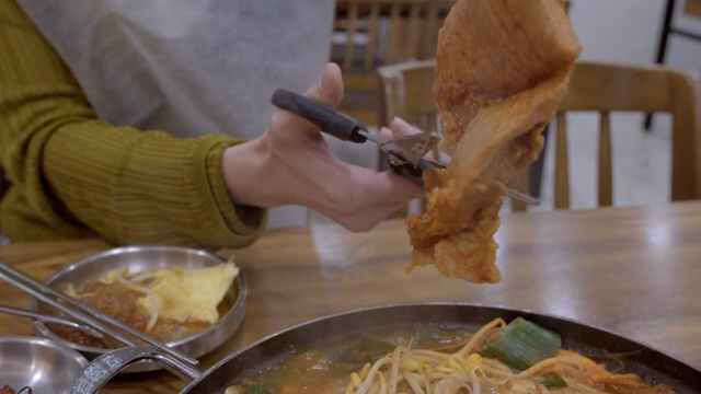 뜨거운 전골의 고기를 가위로 자르는 사람