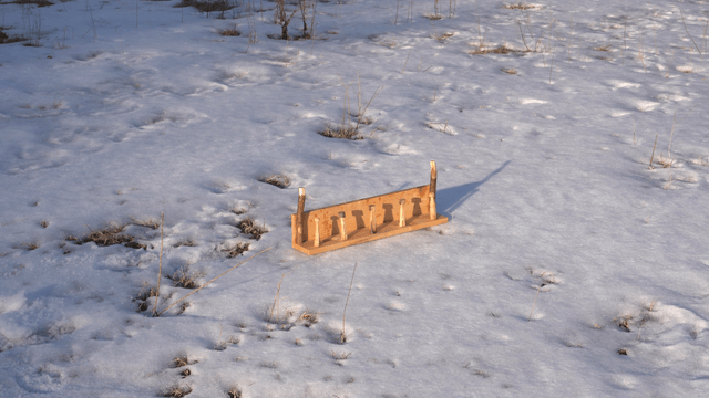 Wooden stand casting a shadow on the snow
