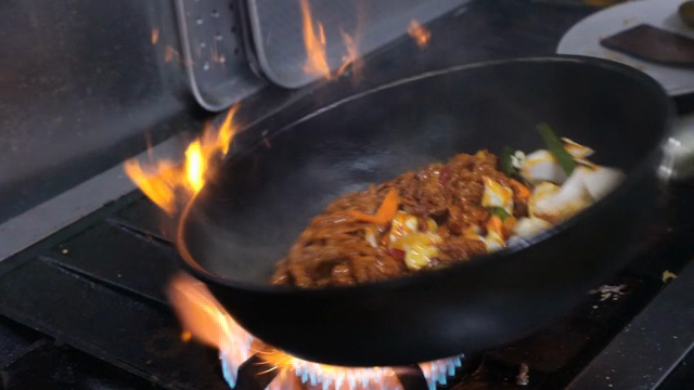 Stir-frying vegetables and meat in a hot pan