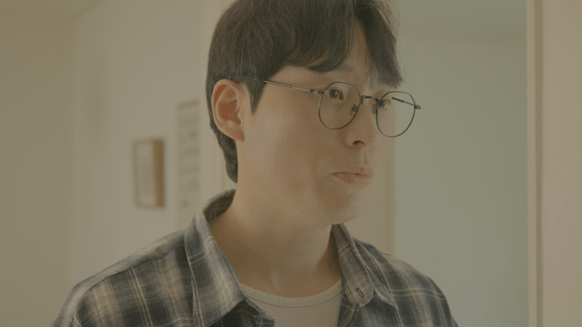 Talking man with glasses wearing check shirt