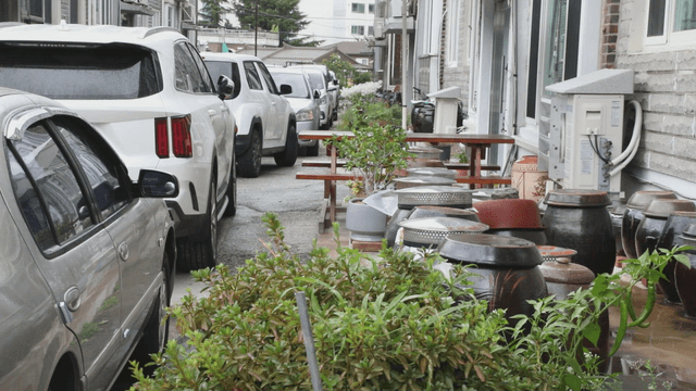 Residential area with parked cars and traditional jars