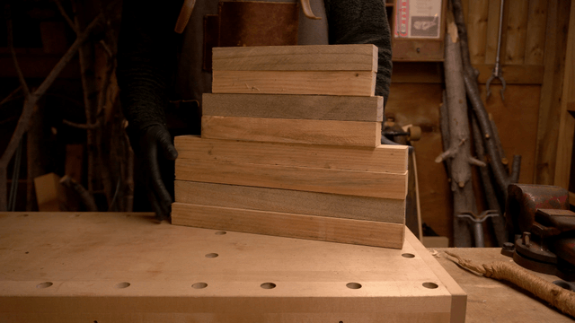 Carpenter stacking and organizing wooden boards