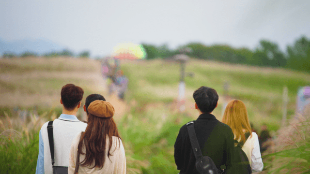 Group of friends walking in a grassy field
