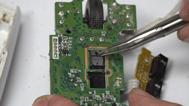 Repairing mouse circuit board components with tweezers