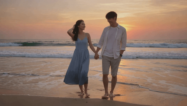 Couple walking toward the camera at sunset on a beach