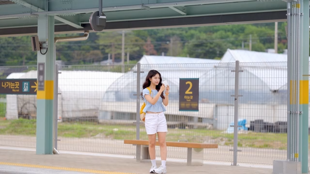 기차역의 젊은 여성과 들어오는 기차