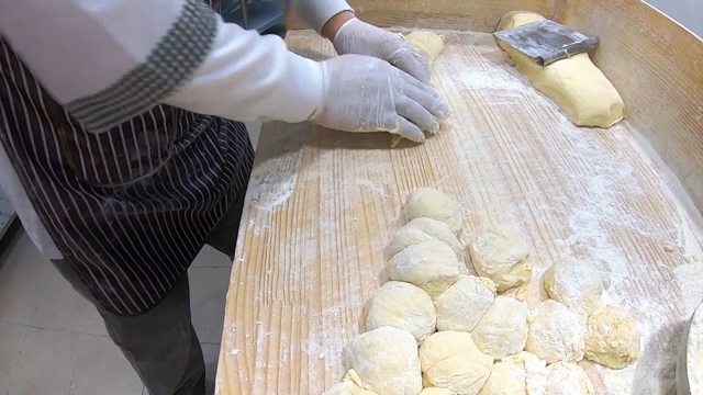 Hands kneading dough on a floured surface