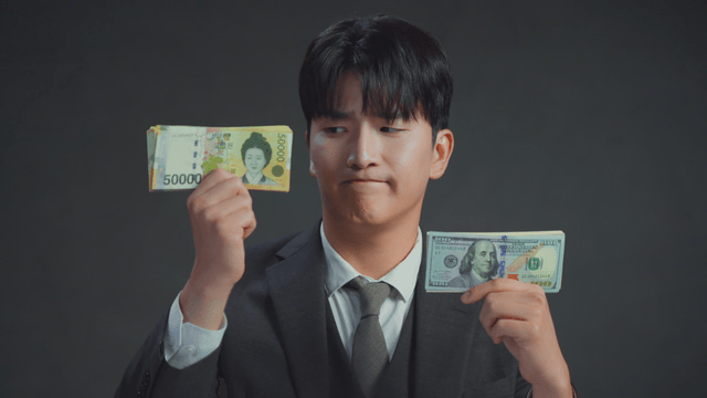 Man smiling at the US dollar bills in his hand