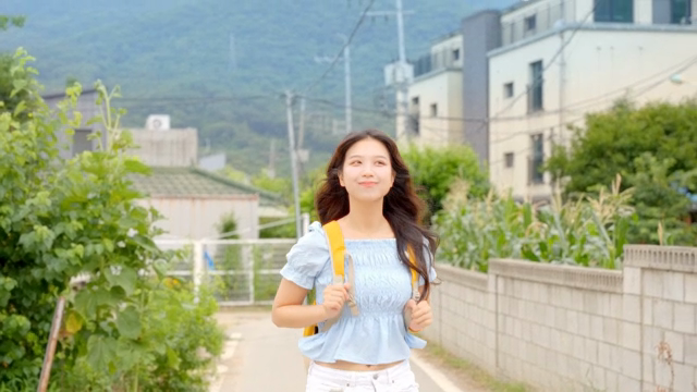 햇살 좋은 날 걷는 젊은 여성