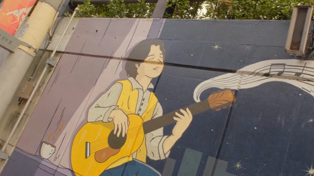 Street mural of a musician playing guitar