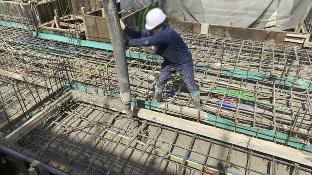 Worker pouring concrete at a construction site