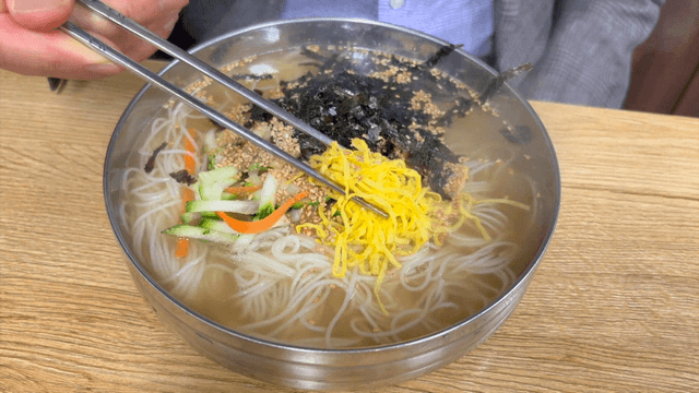 Warm Korean banquet noodles topped with egg garnish