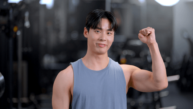 Young man cheering with a smile in a gym