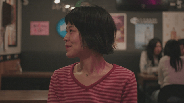 Woman smiling in a striped t-shirt at a pub