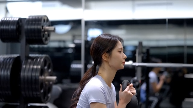 Side view of young woman doing kettlebell squats