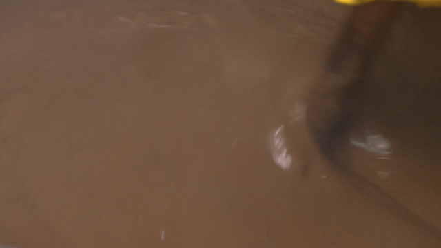 Thick brown sauce bubbling in a pot