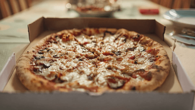 Freshly baked pizza in a box on a table
