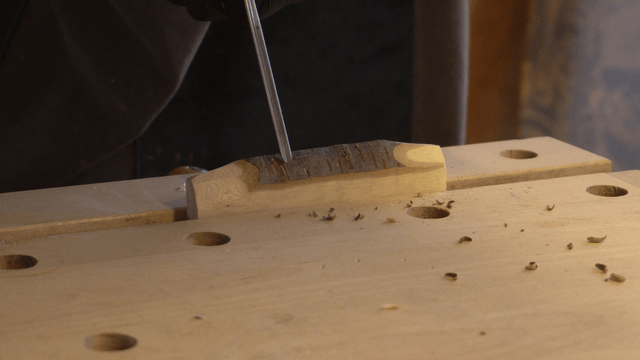 Wood carving process with chisel on workbench
