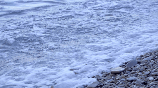 자갈 해변에 부드럽게 밀려오는 파도