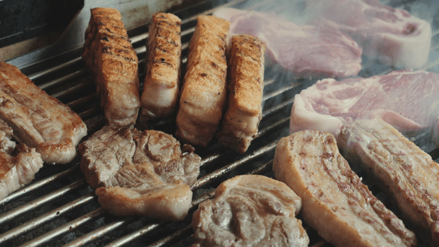 Grilling pork belly on a barbecue grill