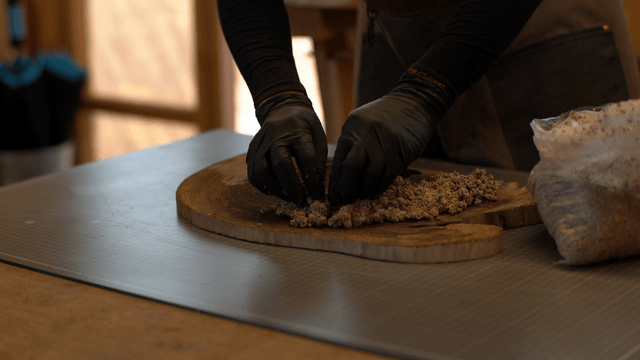 Woodcraft artisan applying sawdust glue mixture onto wooden piece