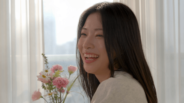Smiling woman by window with sunlight