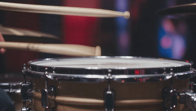 Drumsticks hitting a snare drum
