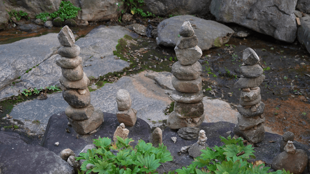 Stacked stone towers by a quiet stream