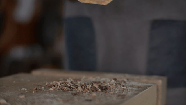 Woodcraft artisan holding a half-moon wooden piece