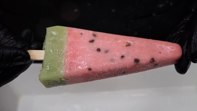 Watermelon-shaped popsicle being held