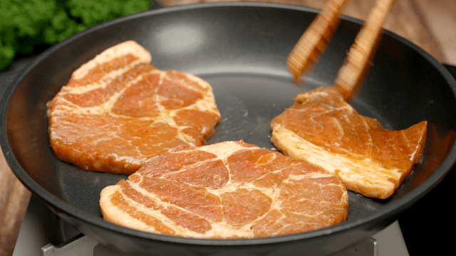 Marinated pork slices cooking in a pan