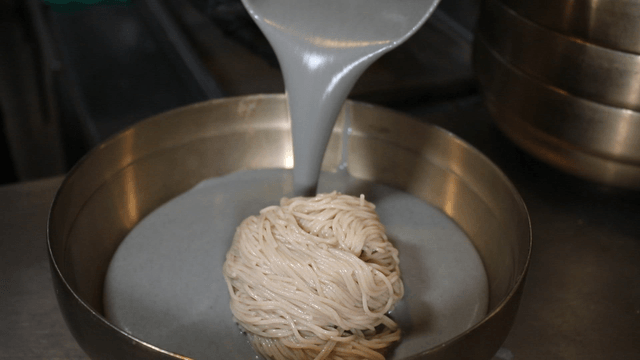 Black bean liquid poured over buckwheat noodles