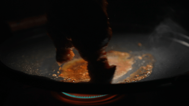 Steak sizzling on a hot pan