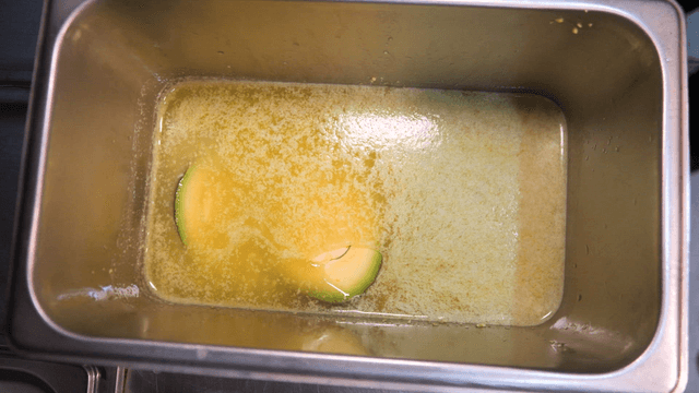 Avocado placed in an oil-filled tray