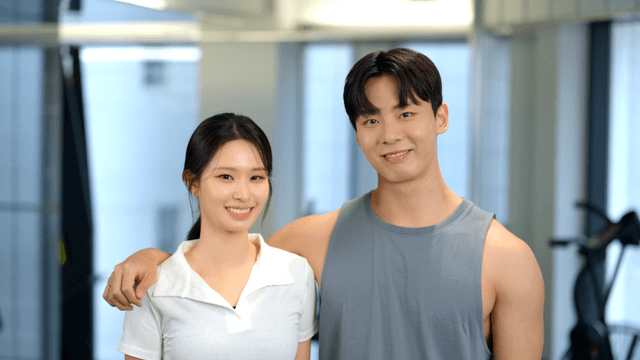 Smiling couple facing forward at the gym