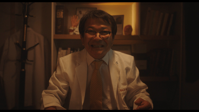 Doctor smiling while explaining in dark office