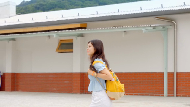 기차역에서 배낭을 메고 걷는 젊은 여성