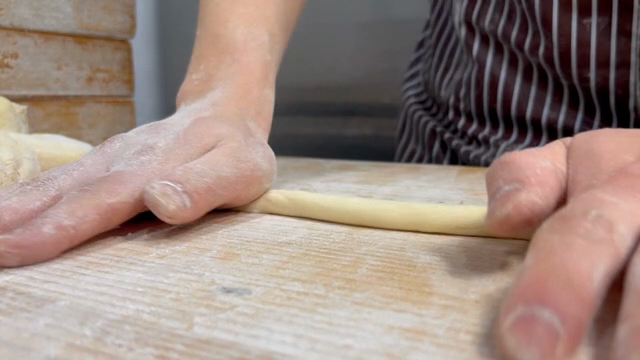 Hands kneading dough on a floured surface