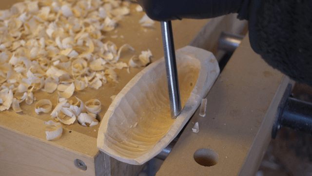 Woodcraft artisan carving wood pieces on workbench