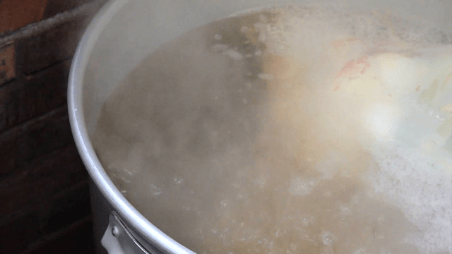 Large pot of clear hot broth boiling