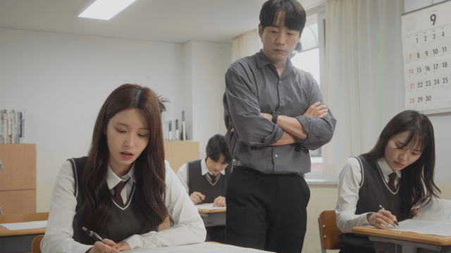 Teacher supervising students during an exam in the classroom