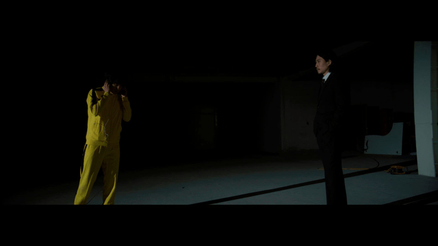 Two men in a dimly lit room